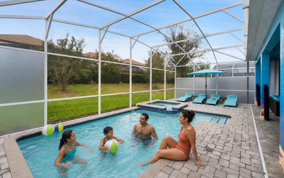 Family relaxing together in the private screened pool at 9099 Hazard Street